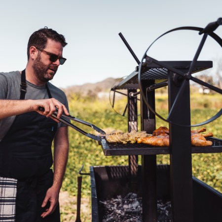 Micah Wexler cooking chicken on a grill.