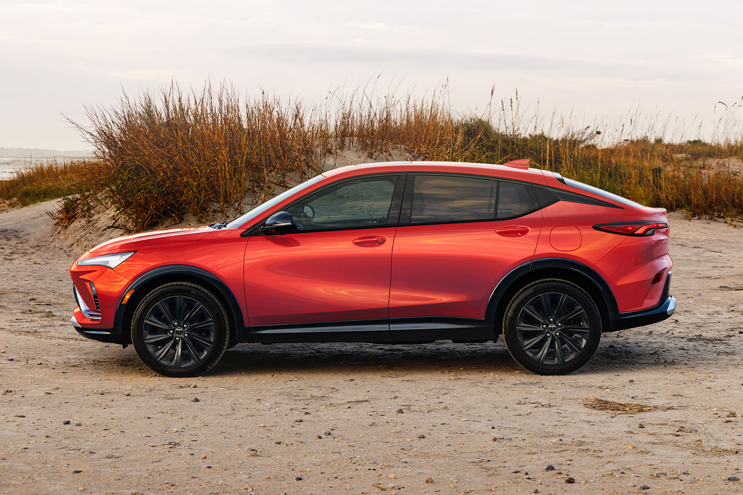 A red 2024 Buick Envista ST SUV sitting on the beach. It's one of our favorite affordable crossovers on the market.
