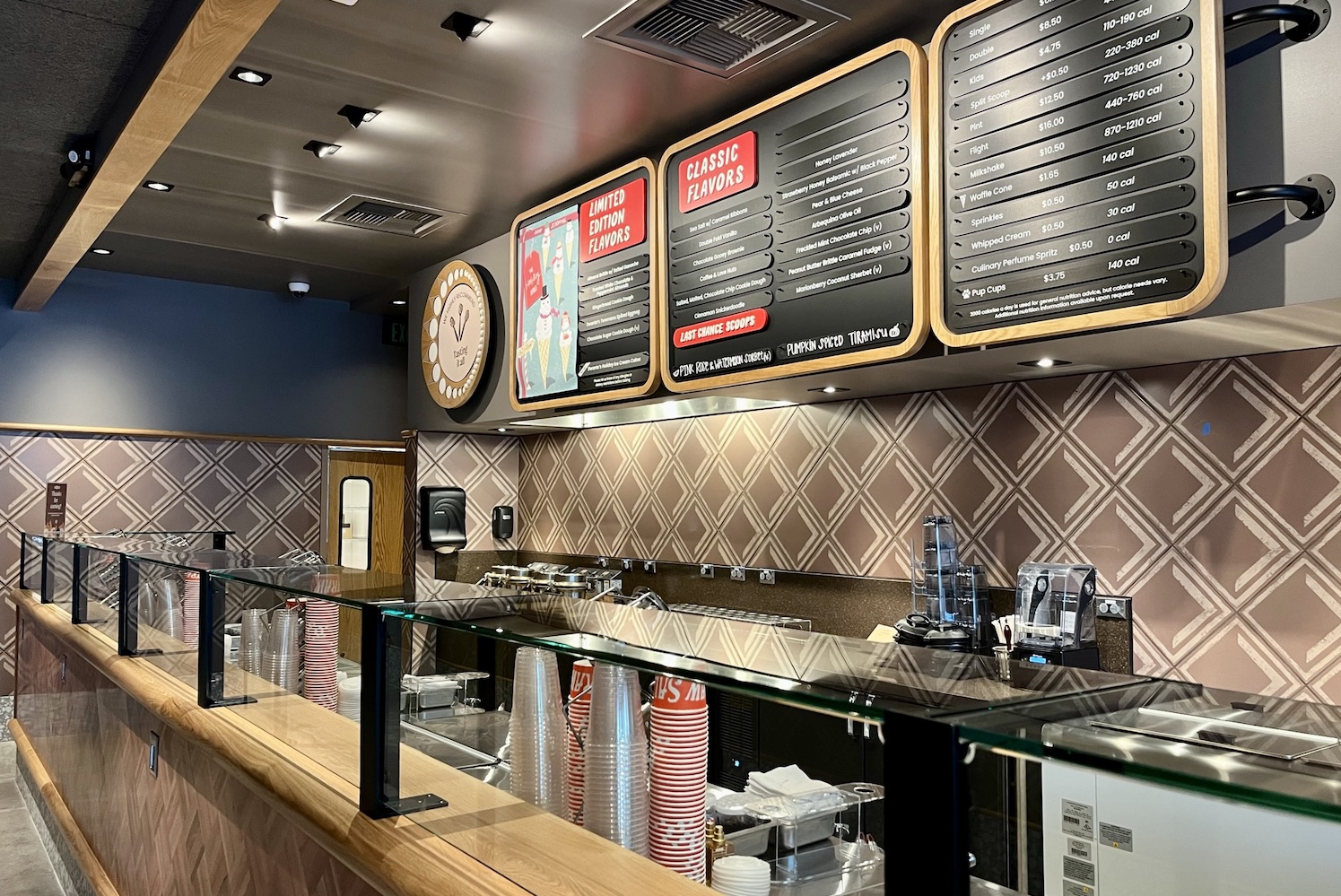 Interior of Salt & Straw, showing a long counter with hanging menus 