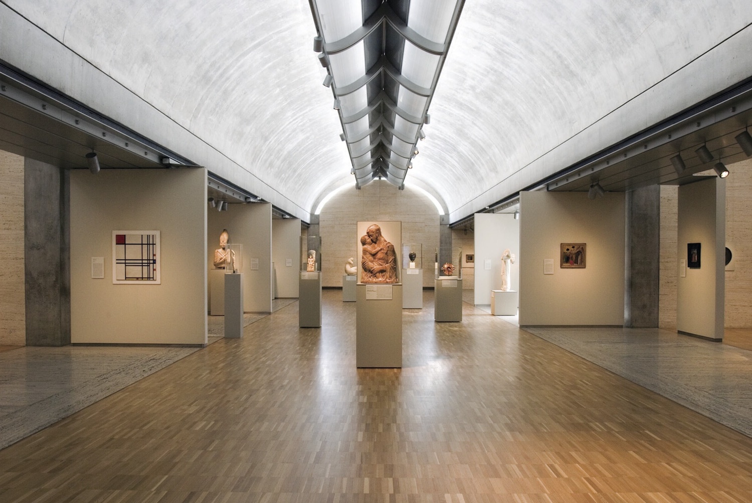 Interior of Kimbell Art Museum, with statues and posters on walls 