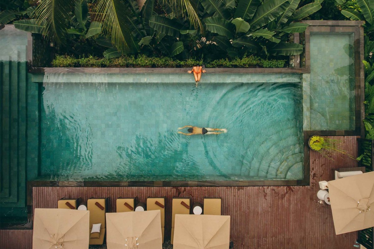 People at a luxury resort in a swimming pool. 2024 is going to be a banner year for luxury travel.