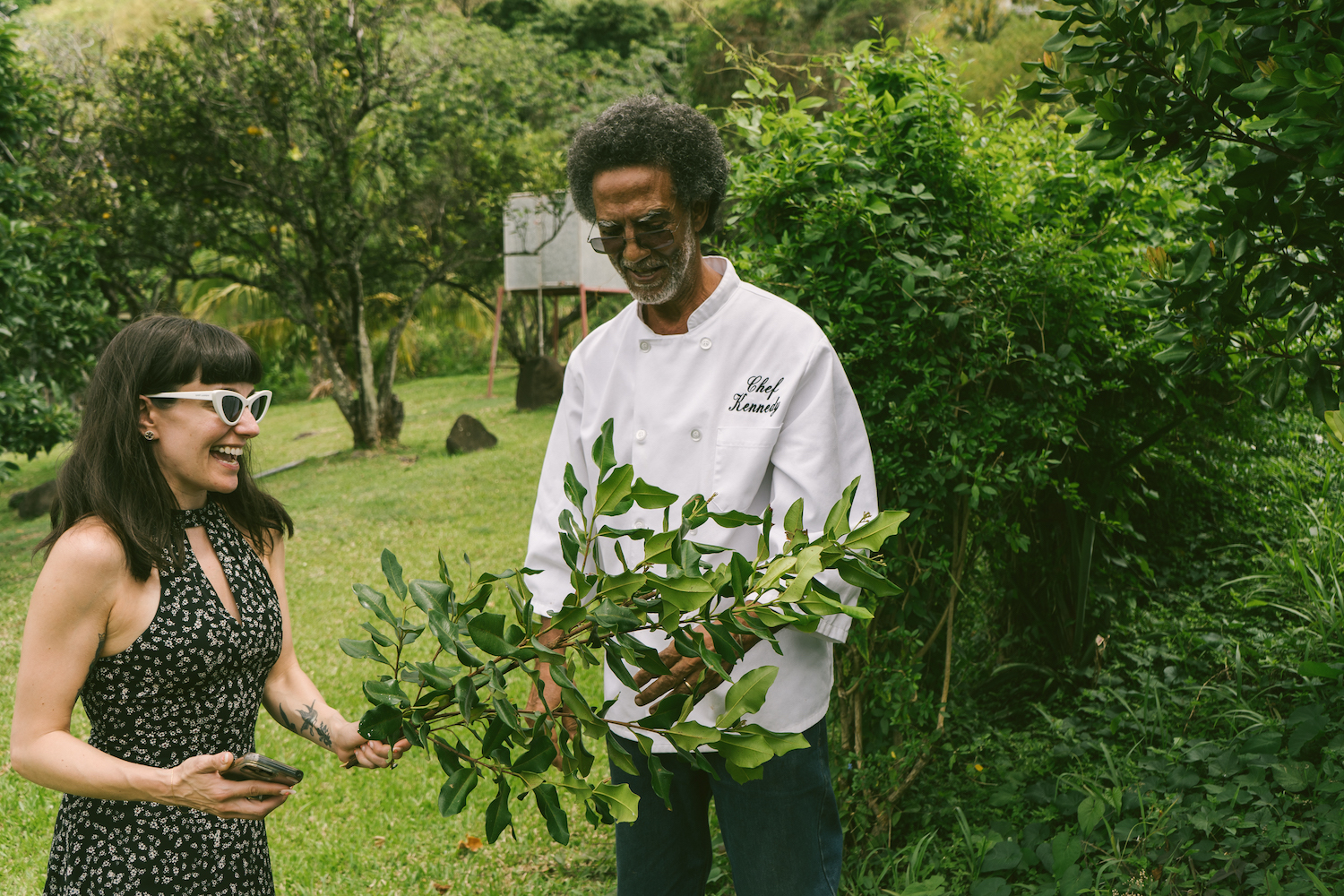a woman and man standing with a branch of bay leaves