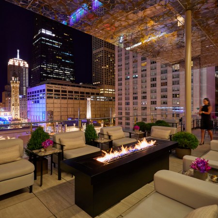 Rooftop seating area with fireplace overlooking Chicago's city skyline at the Peninsula hotel downtown