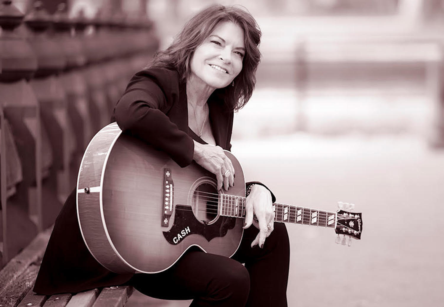 Rosanne Cash posing for photo with guitar 