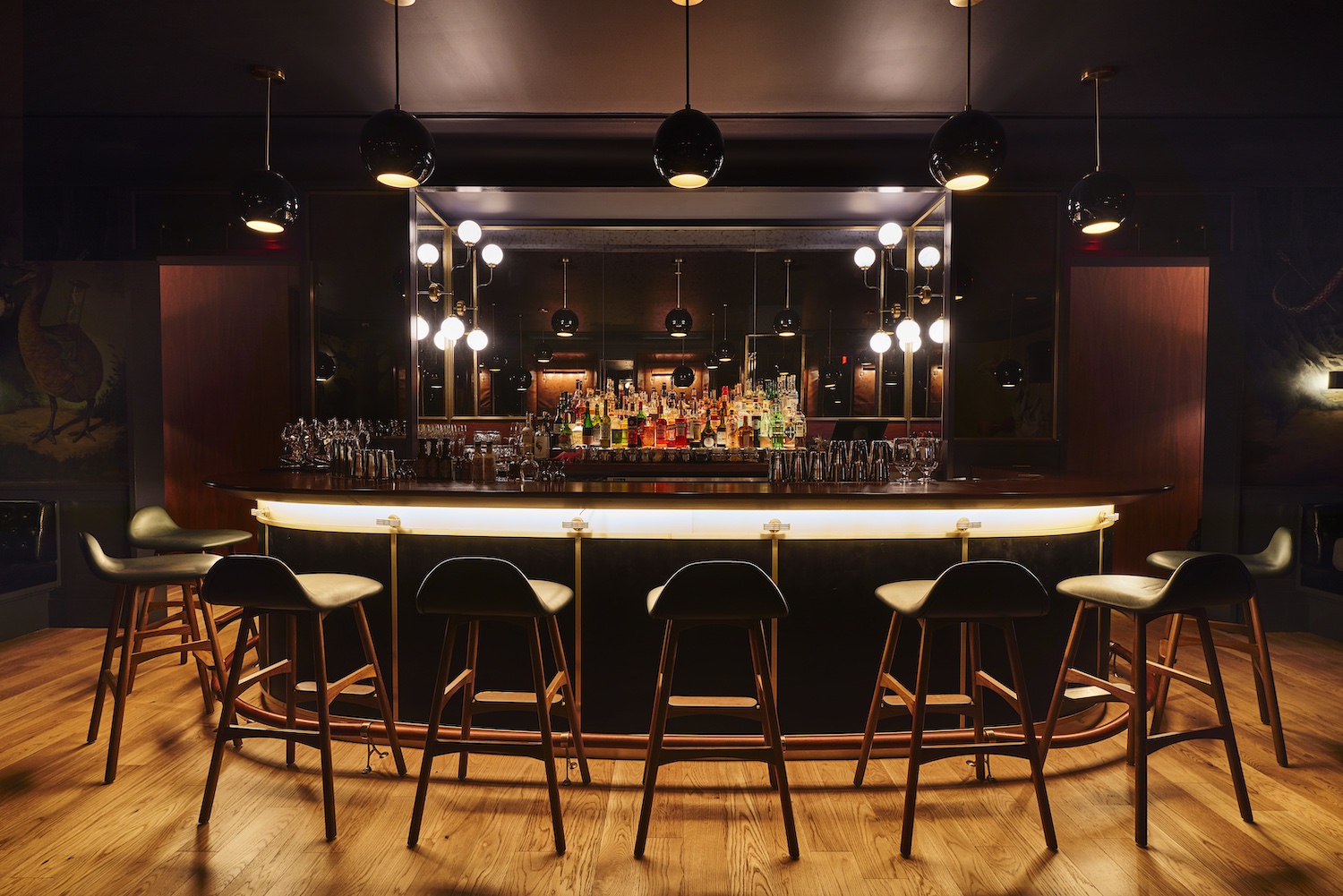 Bar area at Allegory, with round bar and bottles behind it