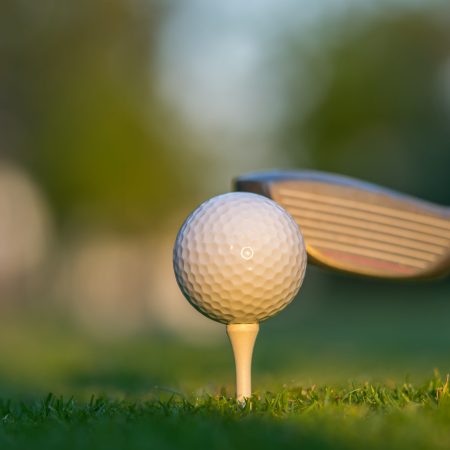 A golf ball on green grass ready to be struck.