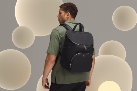 A man wearing the Lululemon New Parent Backpack, a stylish diaper bag that we tested and reviewed