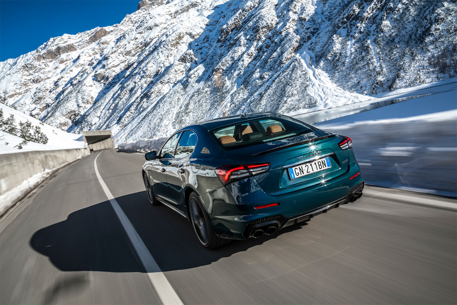 The world's fastest sedan, a Maserati, driving through the Alps in Italy