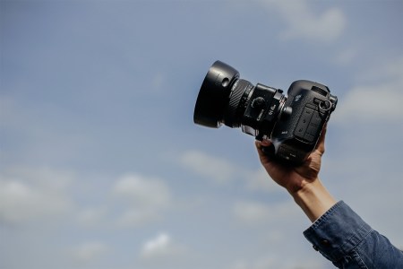 A man holding a camera up into the air.