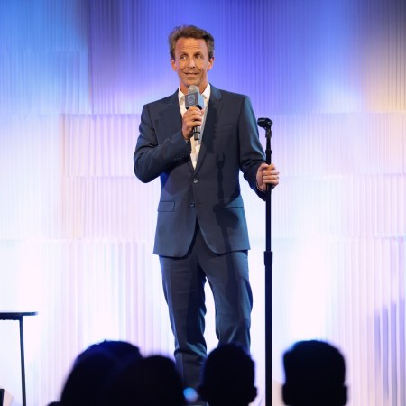 Seth Meyers on stage holding a mic