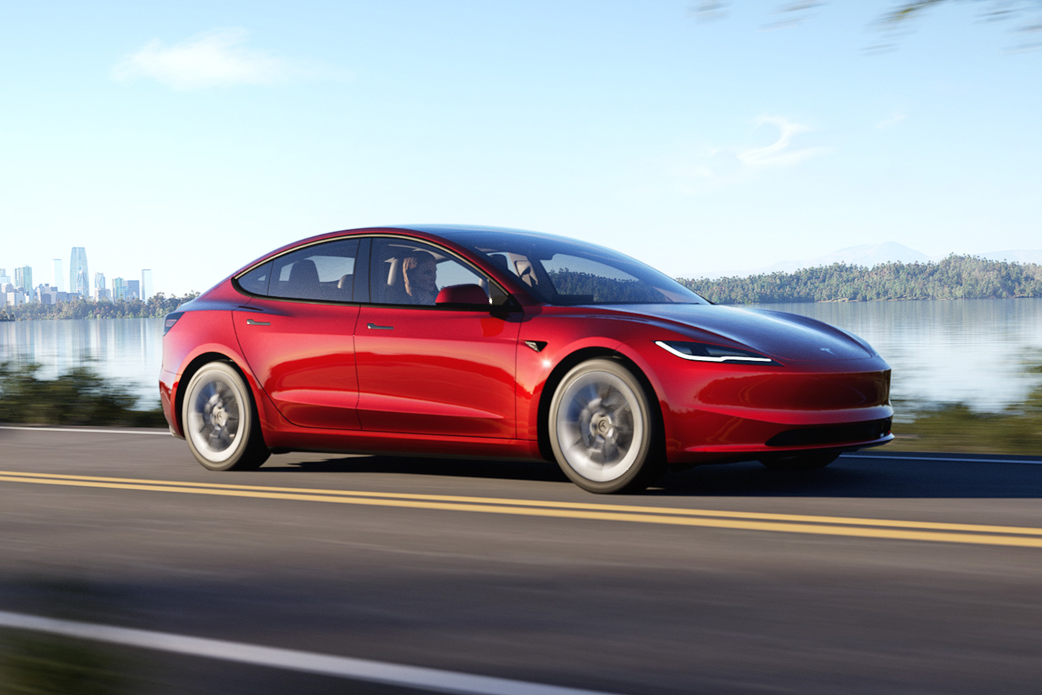 Tesla Model 3 in red driving down the road