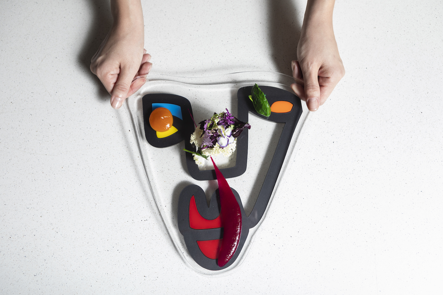 Food being handed out on a platter with flowers in the middle