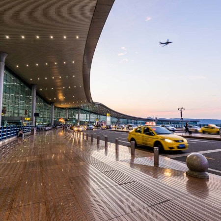 Cars pulling up outside an airport terminal. We look at the first Enrollment on Departure option opening, which could revolutionize the Global Entry process.