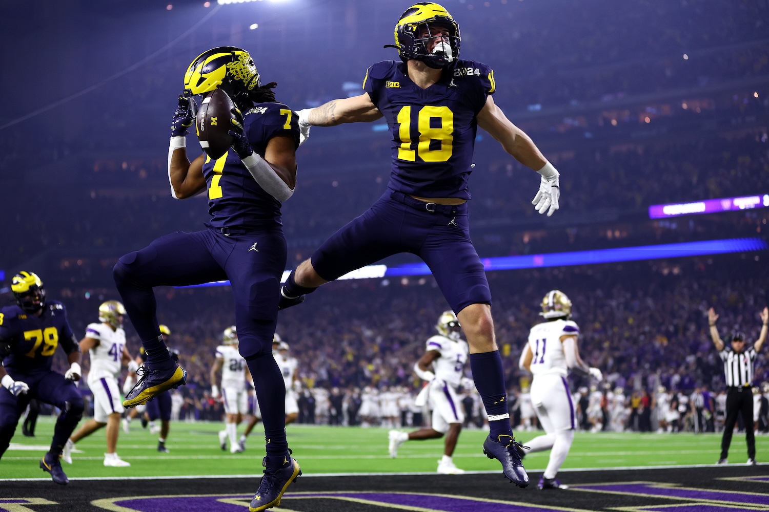 Donovan Edwards #7 of the Michigan Wolverines celebrates with Colston Loveland #18 after running the ball for a touchdown in the first quarter against the Washington Huskies during the 2024 CFP National Championship game at NRG Stadium on January 08, 2024 in Houston, Texas.