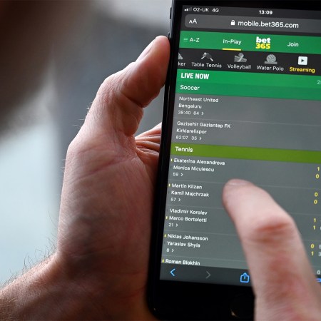 A man's thumb hovering over a mobile betting app. Here's what online gambling is doing to our brains and bodies.