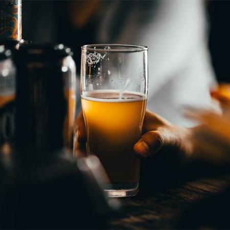 A person drinking a non-alcoholic beer at a bar. NA beer is helping Dry January become a year-round phenomenon.