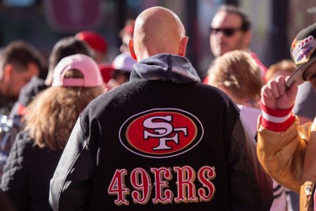 The logo of the San Francisco 49ers on the back of a fan's jacket.