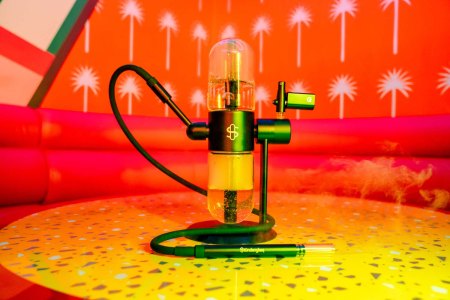 Stüdenglass Gravity Infuser on a terrazzo table in red and yellow lighting