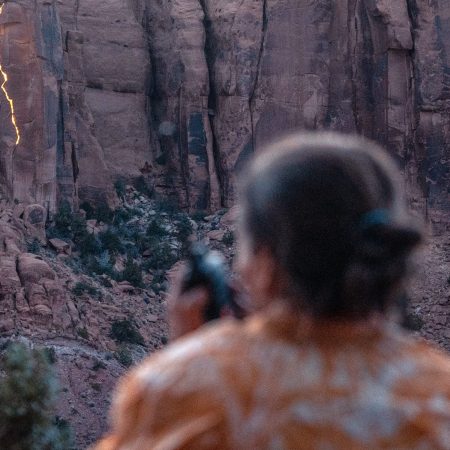 Photographer Krystle Wright takes stationary images of her lighting design on a Long Canyon cliff face.