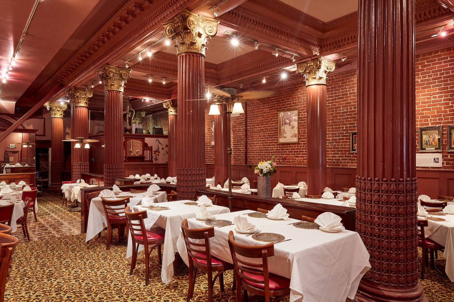 inside of restaurant, columns, tables with tablecloths, chairs 