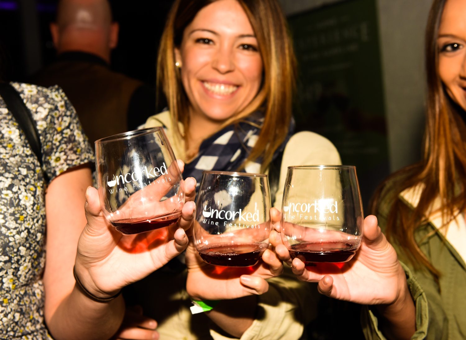 women holding three glasses of wine
