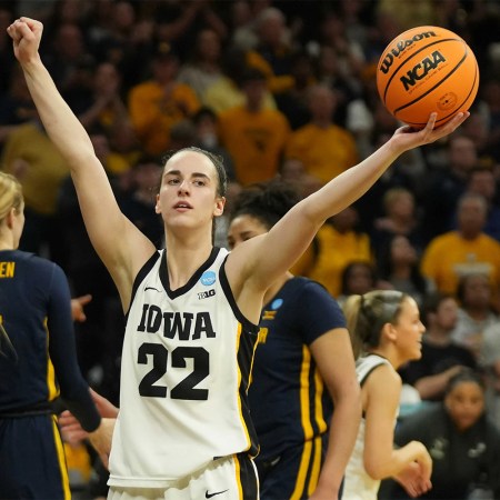 Caitlin Clark of the Iowa Hawkeyes hold a basketball up at an NCAA game. Ice Cube says he offered her $5 million to play in the Big3 league.