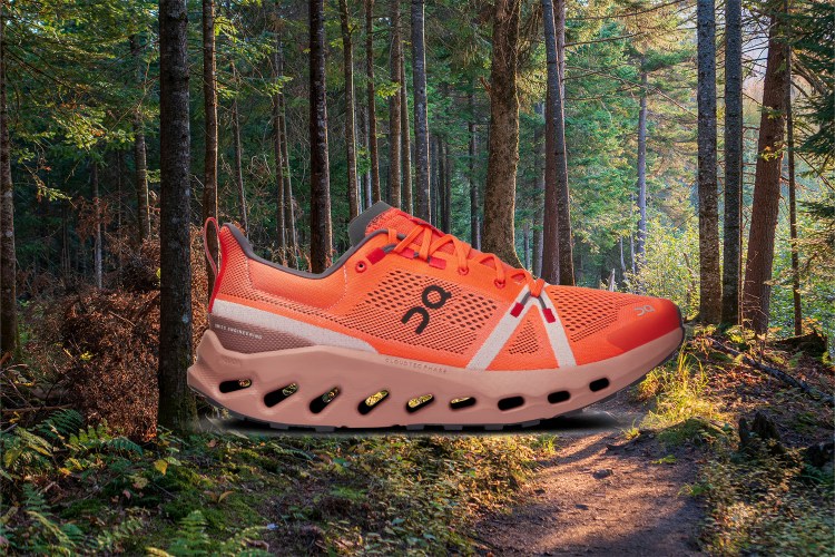 The On Cloudsurfer Trail, a trail-running shoe, against a forest background. Here's our full review of the shoes.