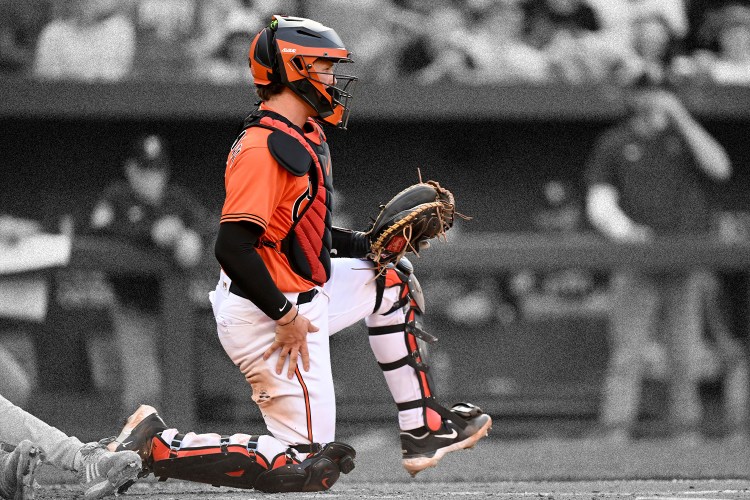 A catcher for the Baltimore Orioles stretches his leg out to one side. Here's what we can learn from the mobility routines of MLB catchers.