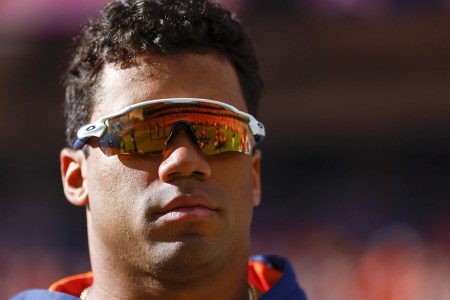 Russell Wilson of the Denver Broncos watches his team warm up. Will cutting him help the Broncos cure their eight-year Super Bowl hangover?