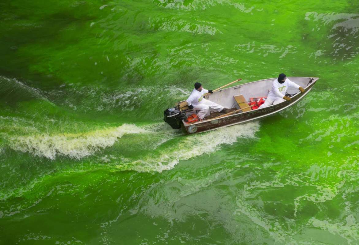 two men in a boat dyeing Chicago river green