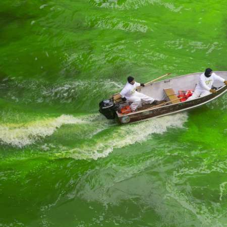 two men in a boat dyeing Chicago river green