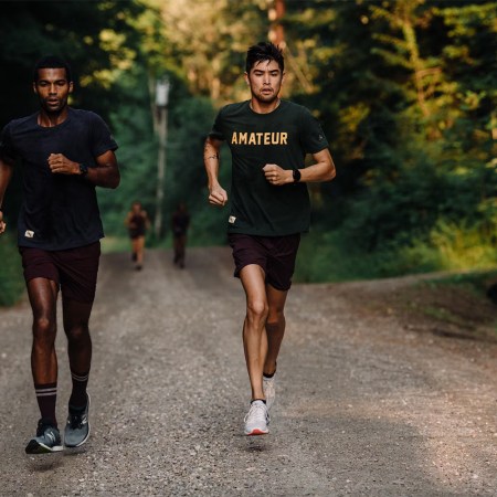 Runners in Tracksmith gear on a woodland trail. Here's how to take advantage of the brand's PR Bonus program.