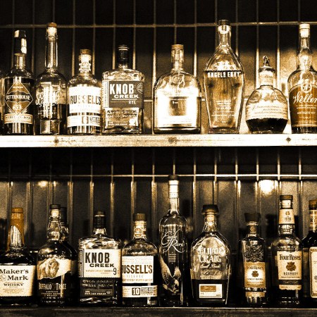 A collection of various whiskey and booze bottles in a liquor store. "Dusty hunters" will score these stores for deals on vintage or overlooked rare bottles.