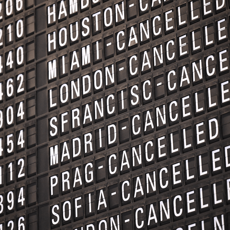 A departure and arrivals board at an airport showing a bunch of canceled flights
