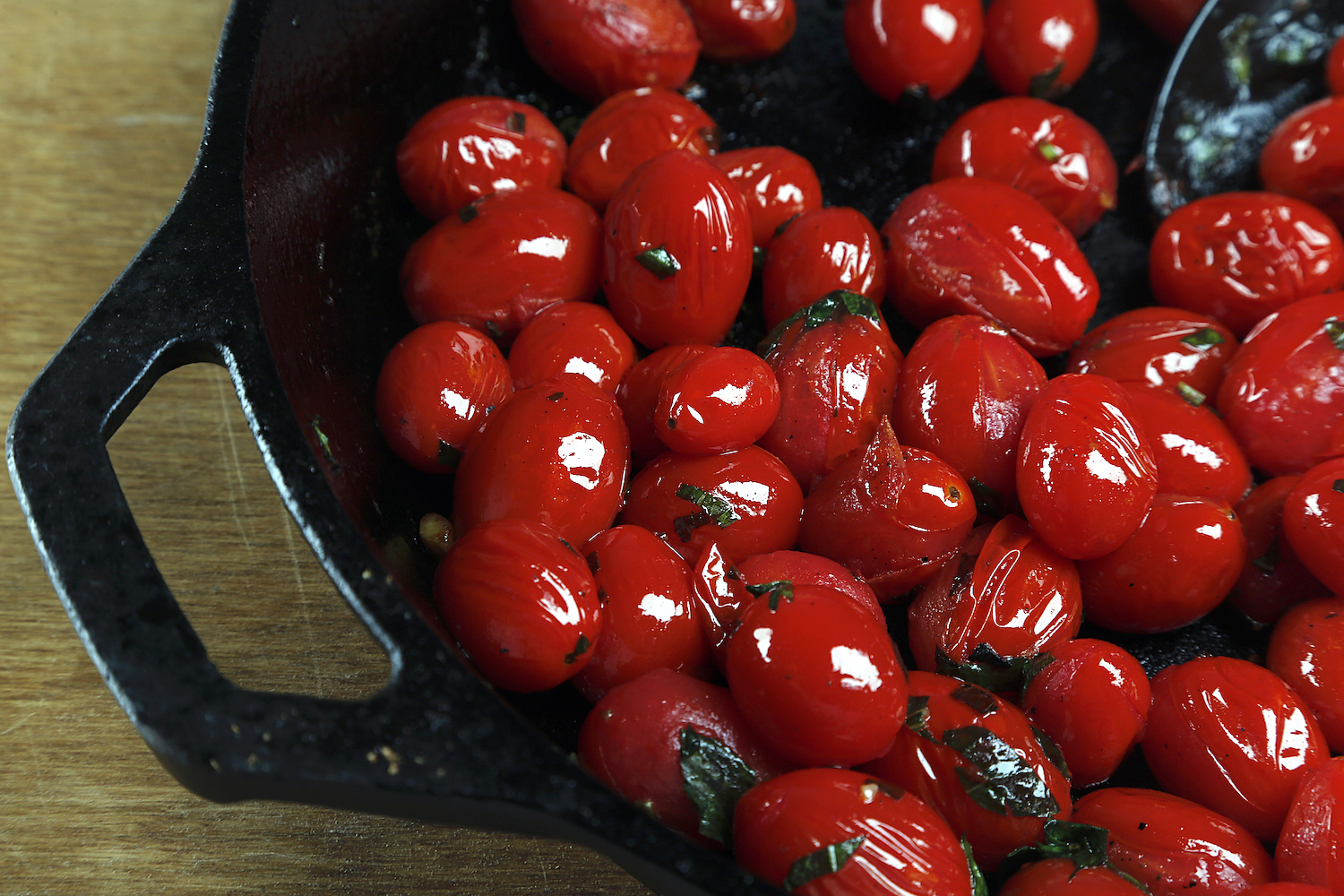 Sauteed cherry tomatoes in a cast iron pan