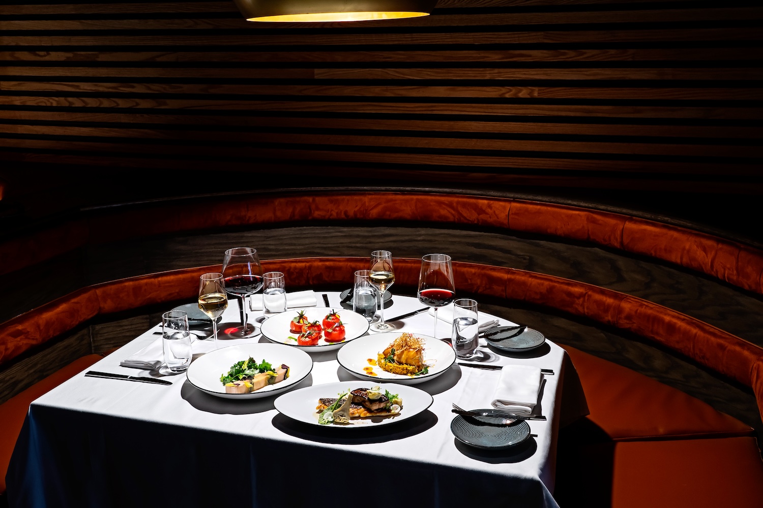 plates of food, wine glasses, burgundy booth