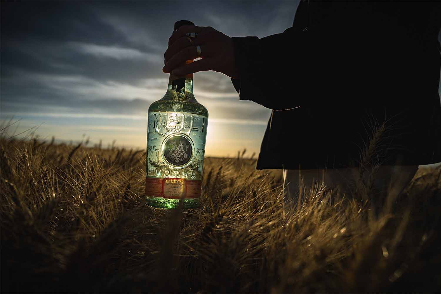 A bottle of Meili vodka in a field