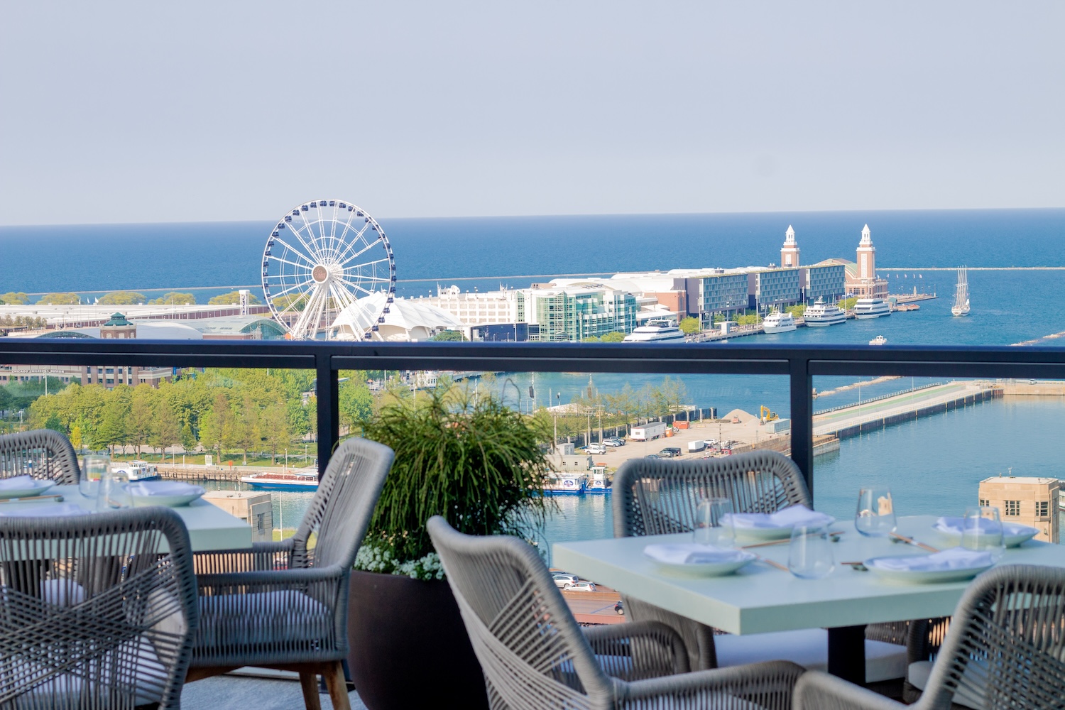 tables, chairs on a terrace, overlooking ferris wheel and boardwalk and ocean