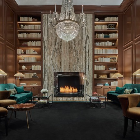 library with chandelier, fireplace, teal chairs