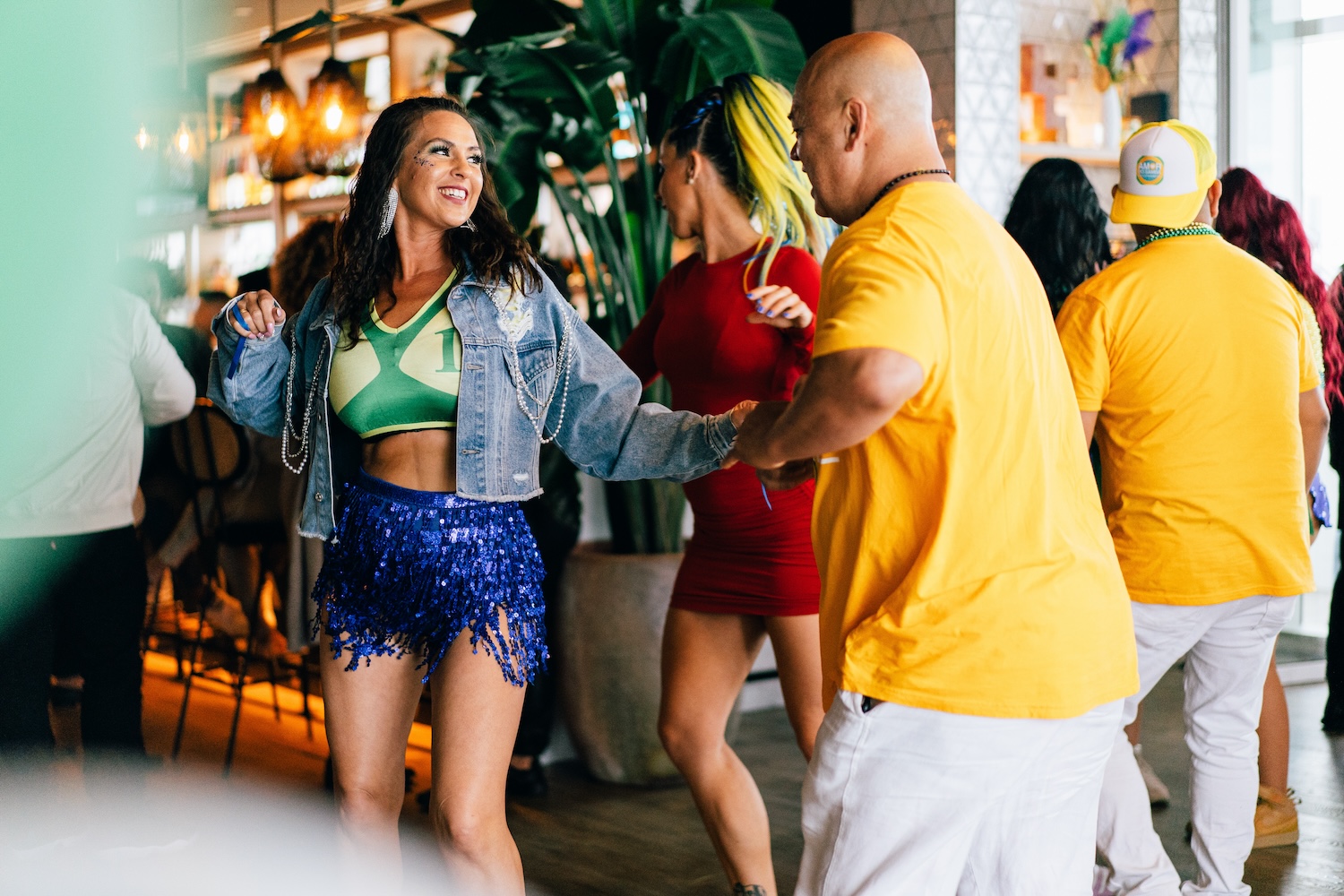 two people dancing, woman in shimmery blue skirt and jean jacket, man in yellow shirt and white shorts
