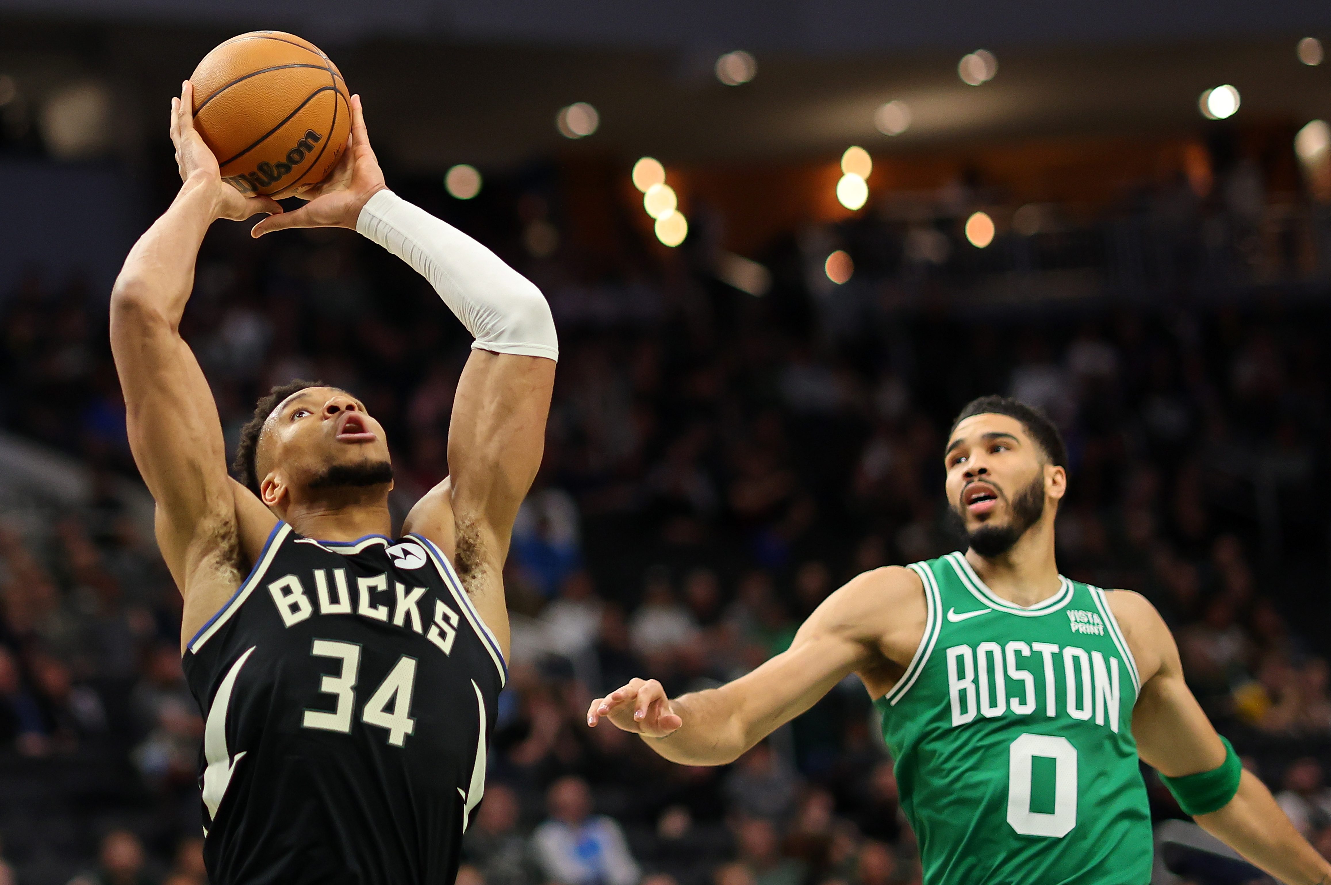 Giannis Antetokounmpo is defended by Jayson Tatum.