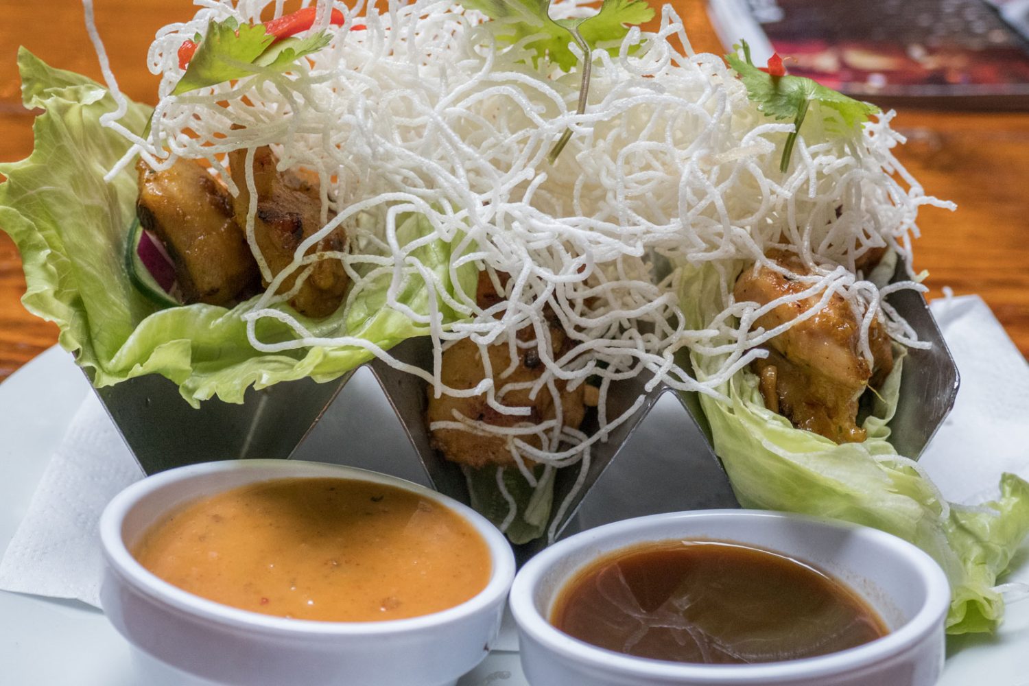 chicken wrapped in lettuce with two sauces