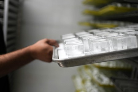 Louis Villegas, owner of Big Ice HTX, pulls out a tray of ice cubes on Monday, Aug. 28, 2023 in Houston. Big Ice HTX creates and sells luxury ice, clear ice cubes with logos or other edible items added to it for bars wanting a more unique presentation