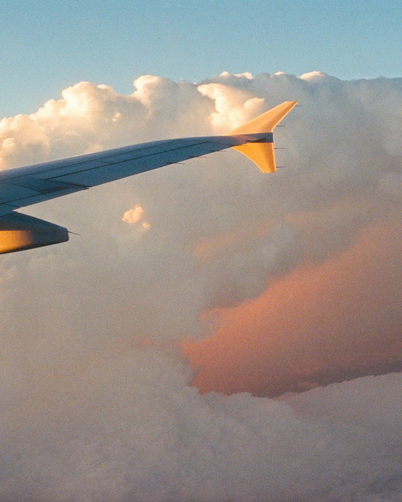A plane wing passing through clouds.