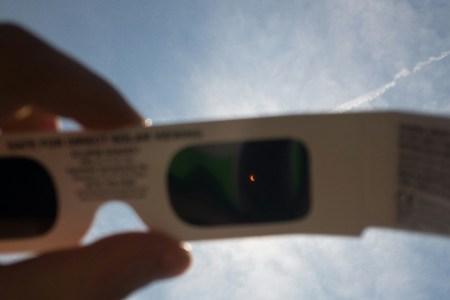 The solar eclipse seen through the frame of eclipse glasses.