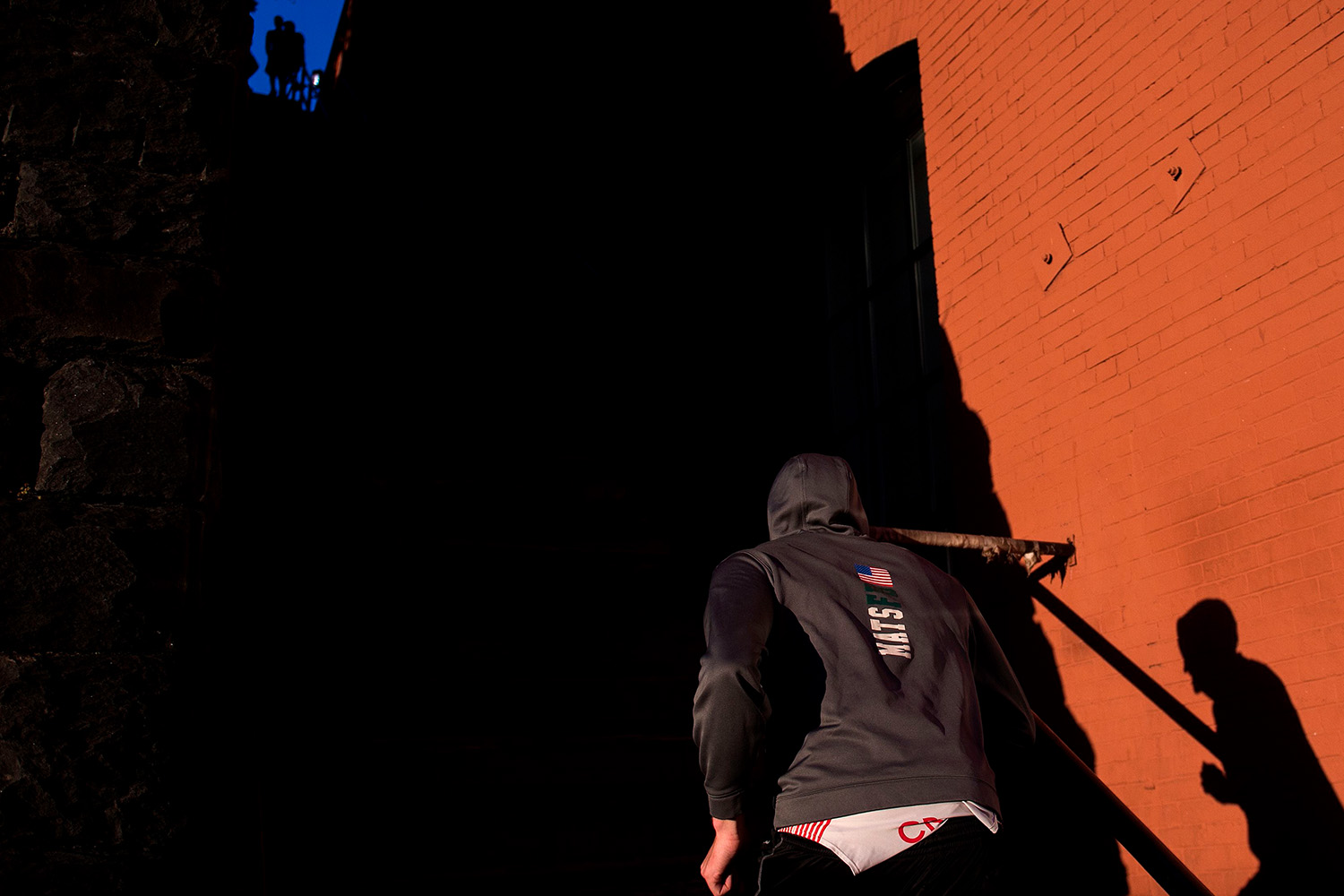 A man running up a set of steps at sunrise.