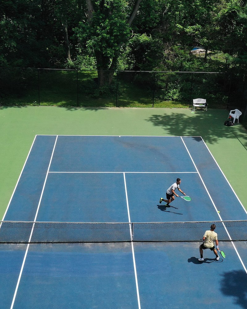 Aerial shot of two men playing tennis.