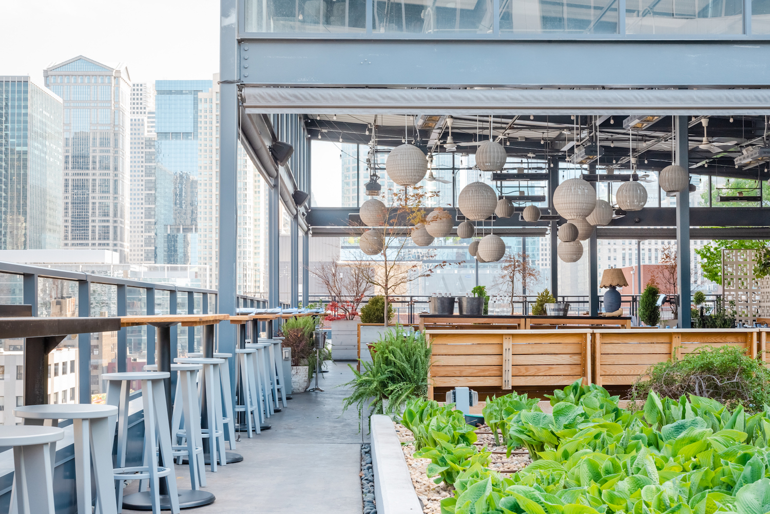 a rooftop bar with stools and hanging round lanterns