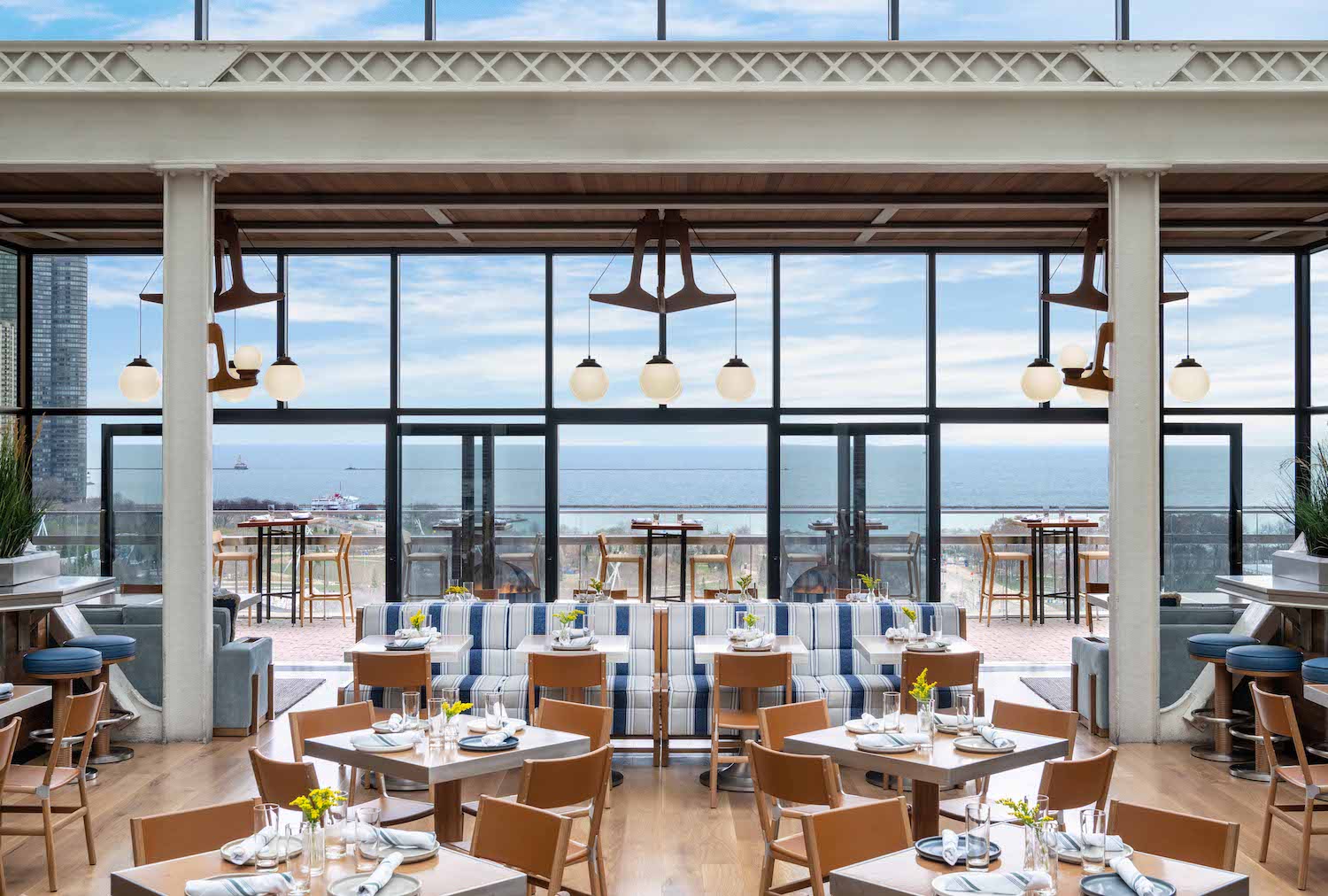 a rooftop bar with striped banquettes and views of lake michigan