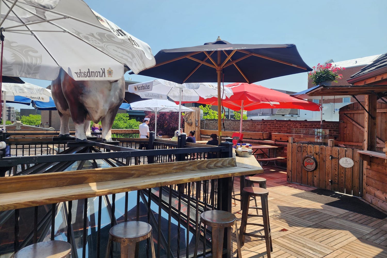 a rooftop bar with umbrellas and a cow statue